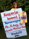 Brigitte Hartwich präsentiert die Plakate für Kasperles Auftritt